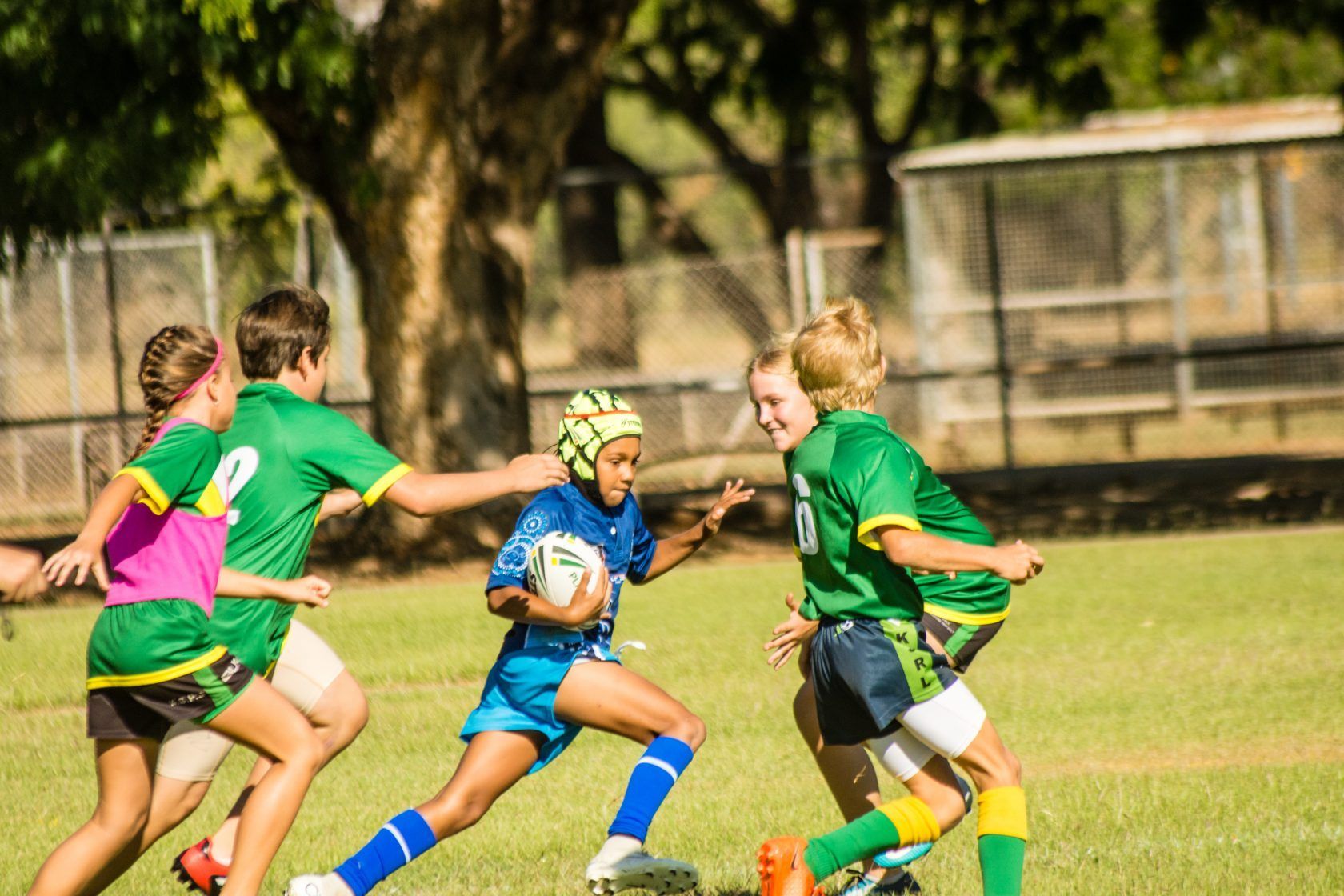 A group of young boys are playing rugby on a field.