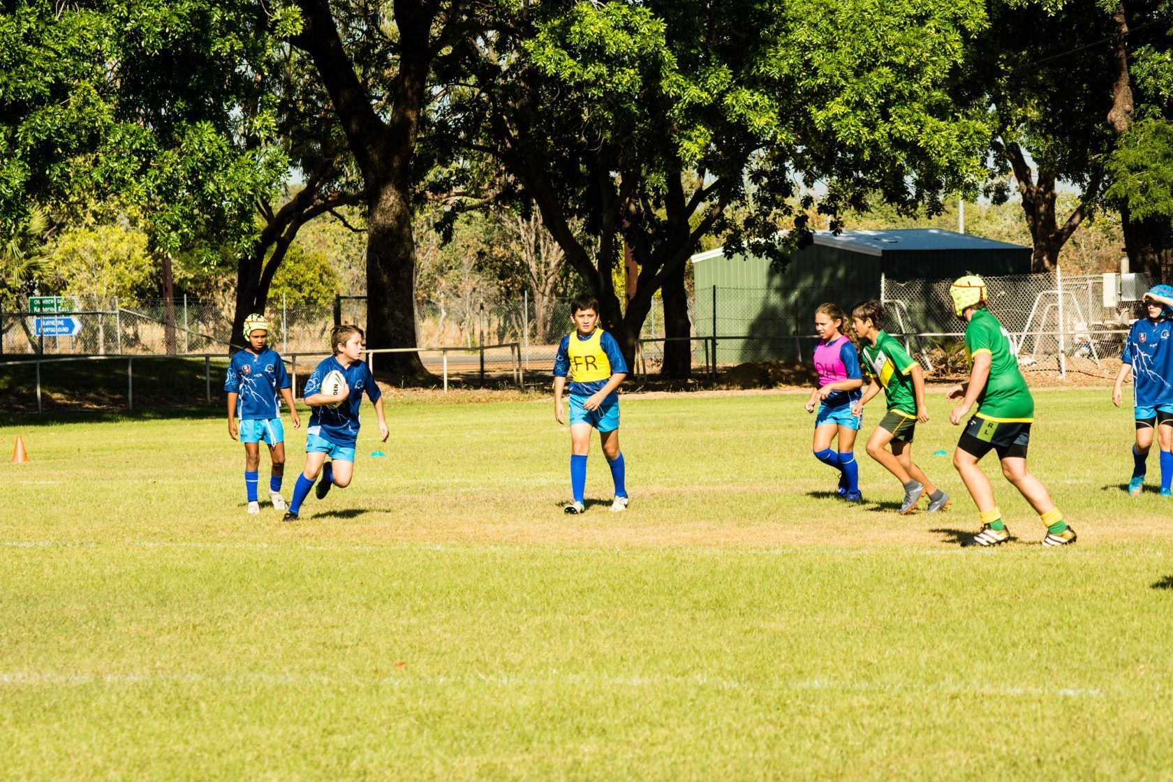 A group of children are playing soccer on a field.
