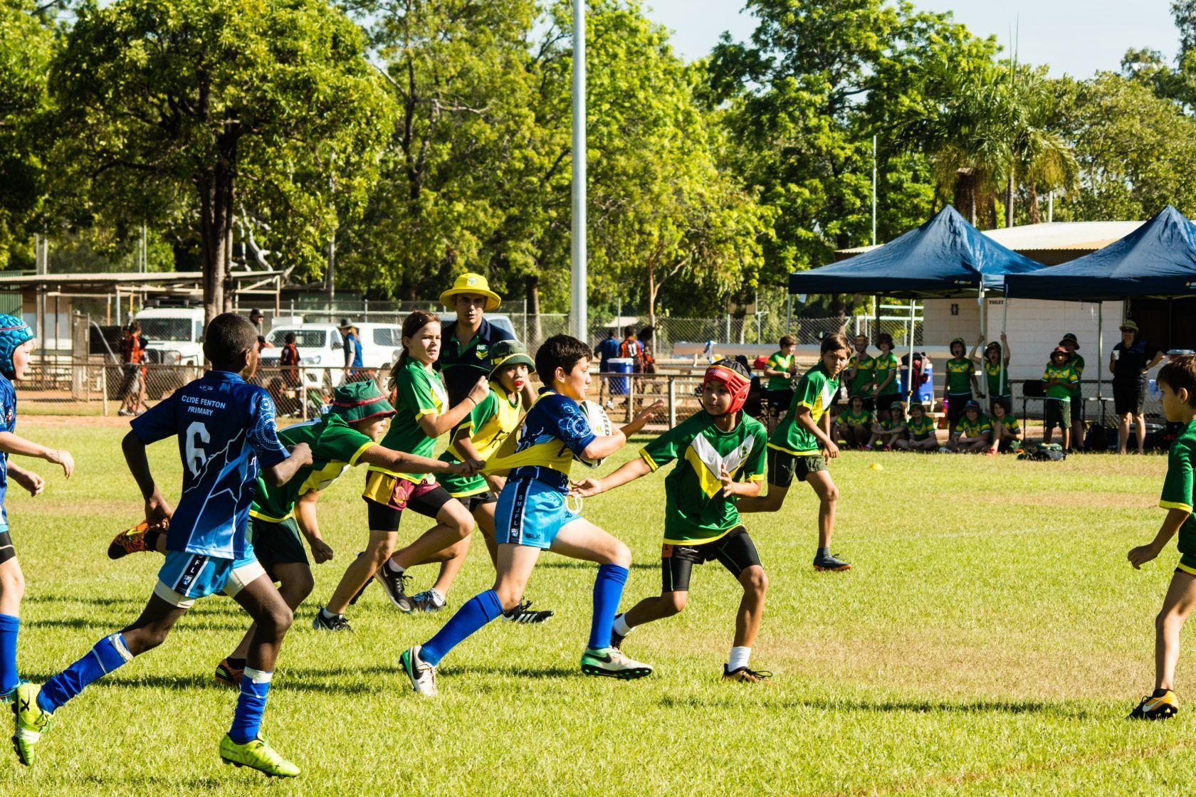 A group of young boys are playing a game of rugby on a field.