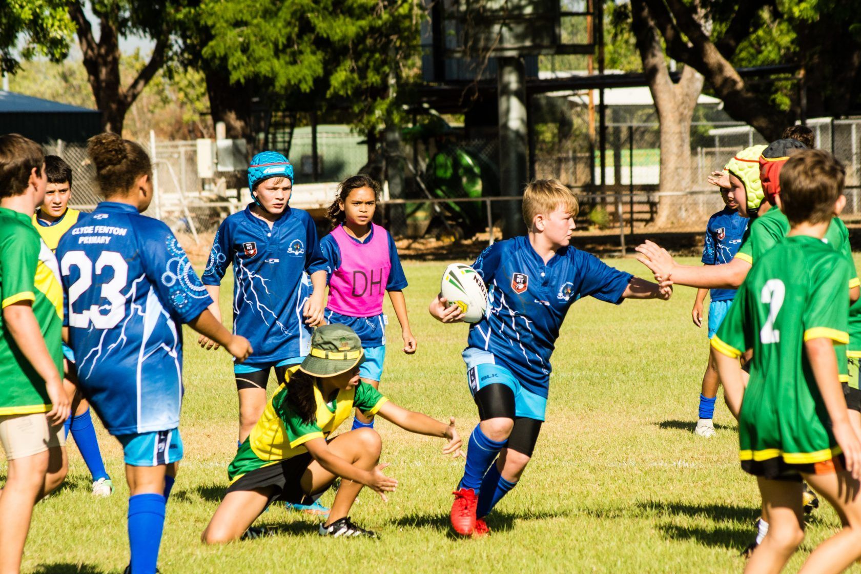 A group of young boys are playing rugby on a field.