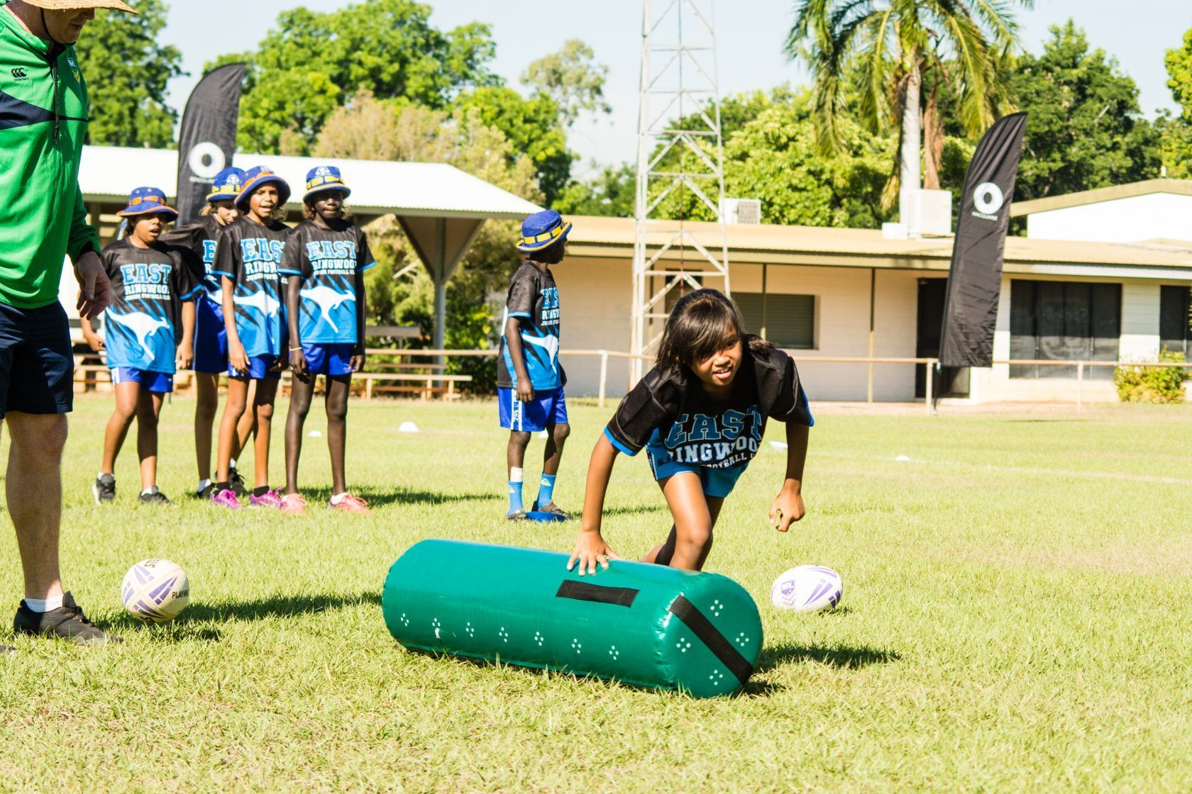 A group of children are playing soccer on a field.
