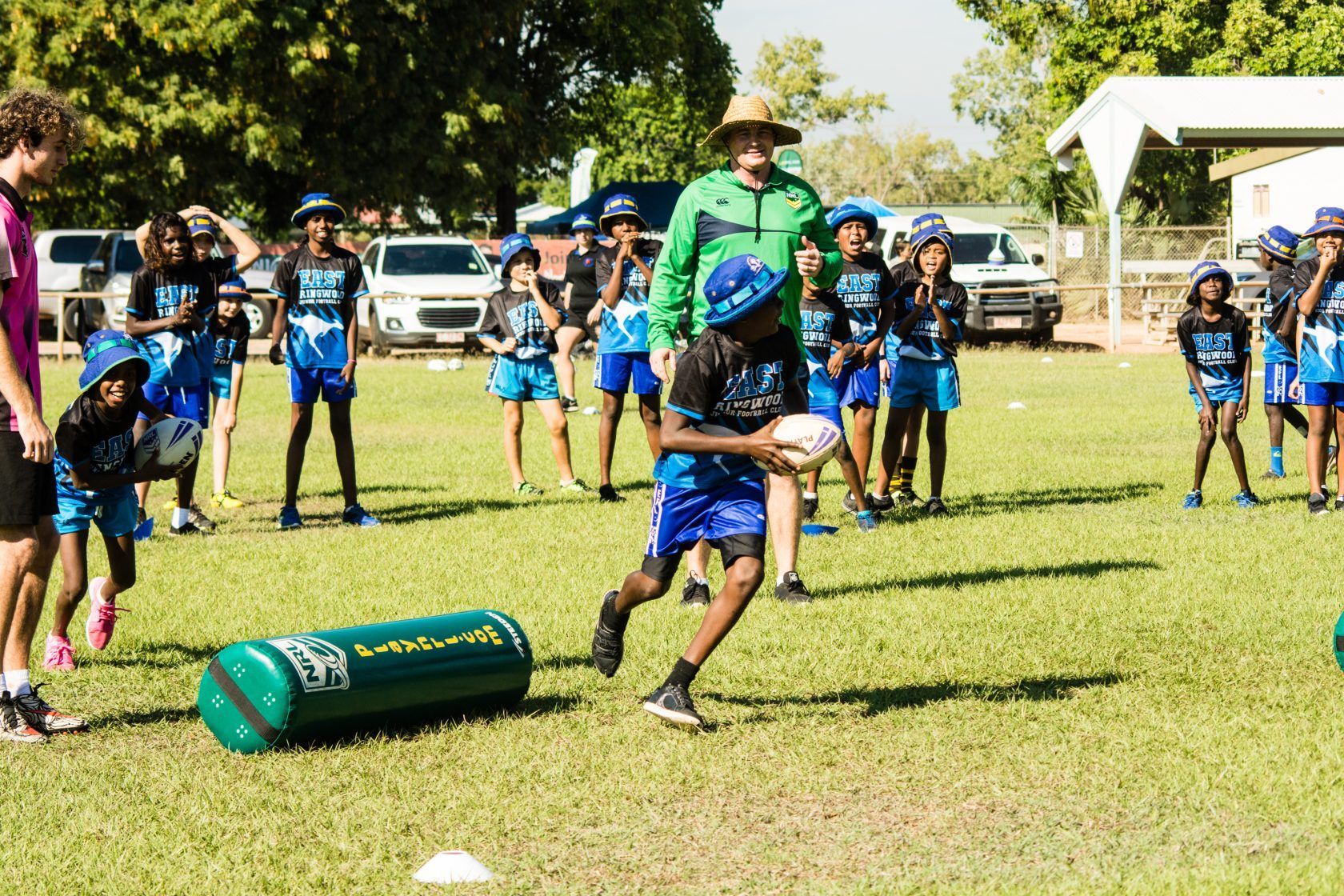 A group of children are playing rugby on a field.