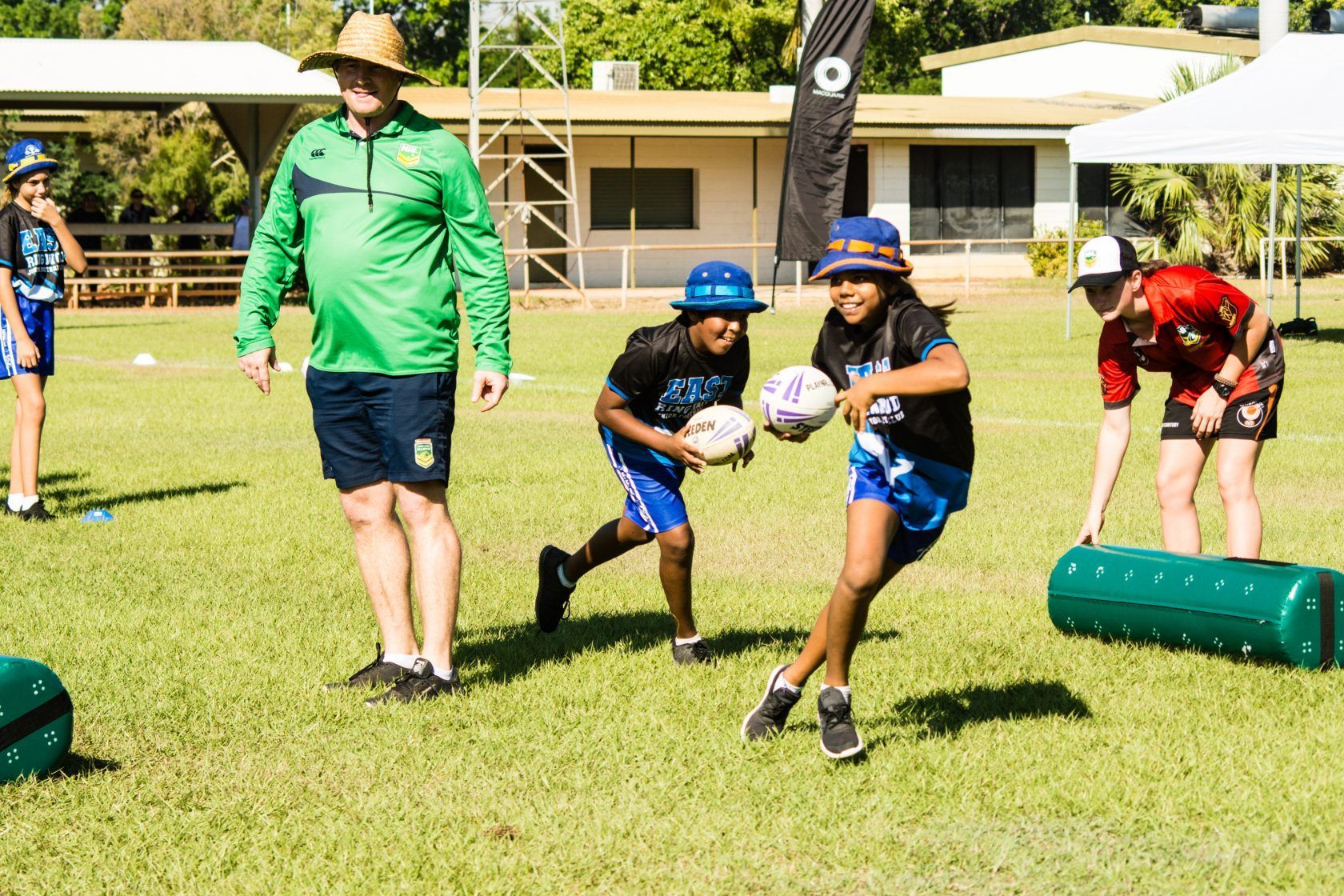 A group of children are playing rugby on a field.