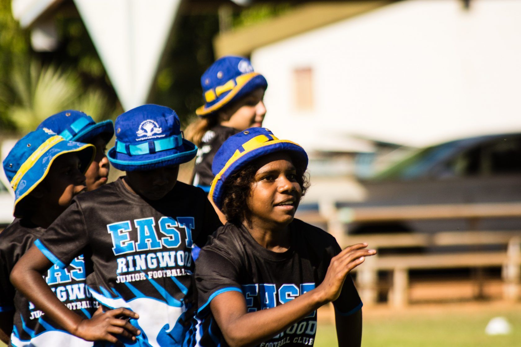A group of children wearing blue hats and shirts that say east kingwood