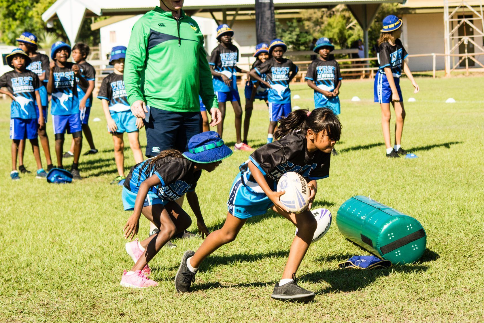 A group of young girls are playing rugby on a field.