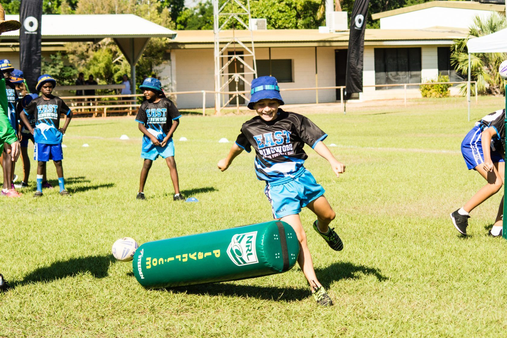A group of children are playing soccer on a field.