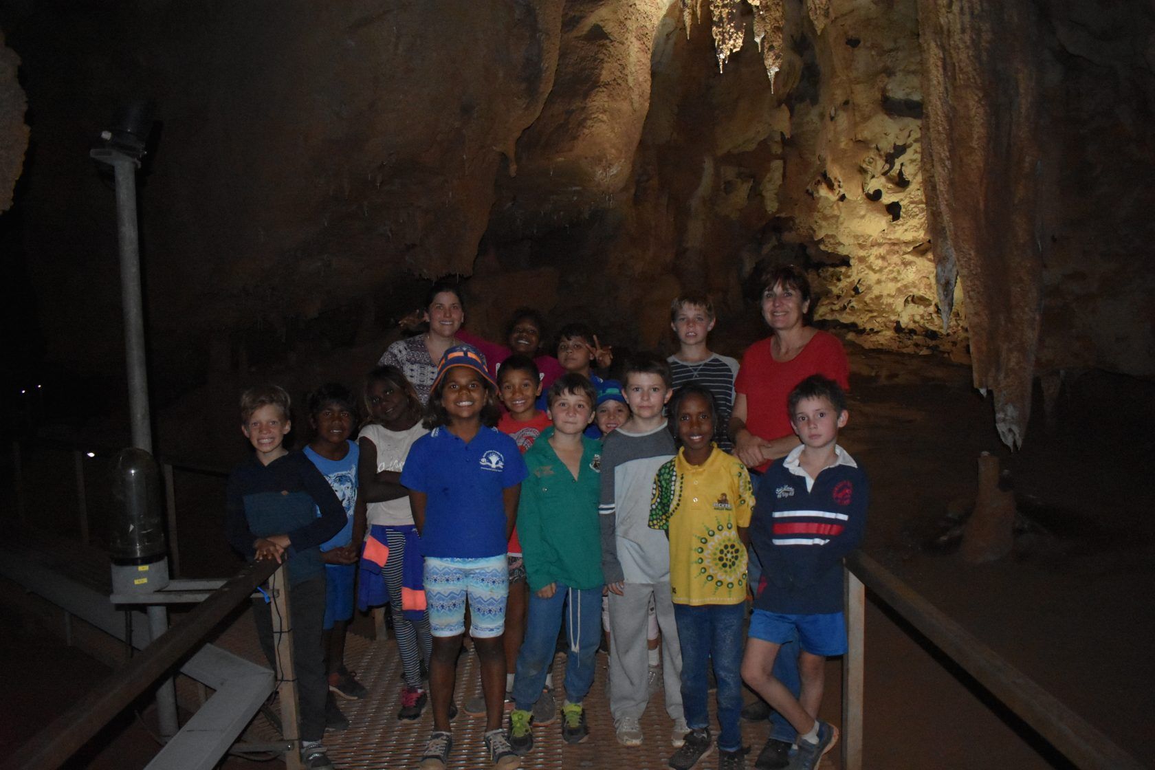A group of children are posing for a picture in a cave