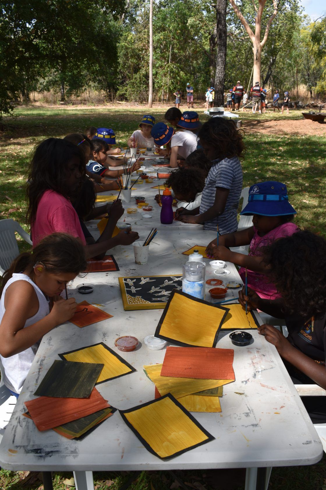 A group of children are sitting at a table making crafts