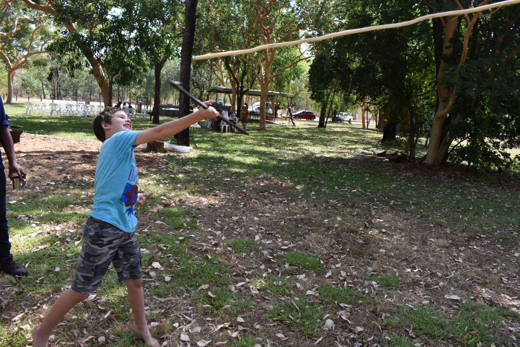 A young boy is throwing a frisbee in a park