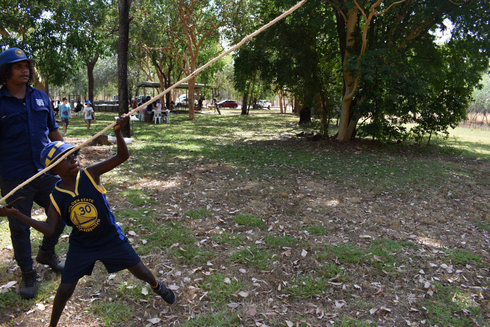 A man and a boy are playing with a rope in a park