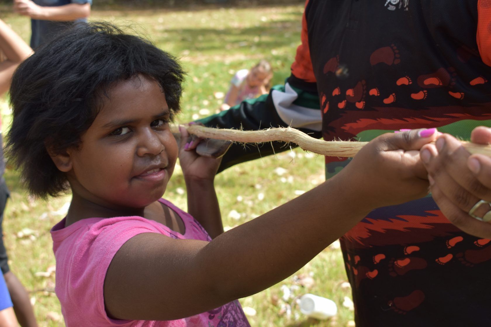 A student holding a stick outside