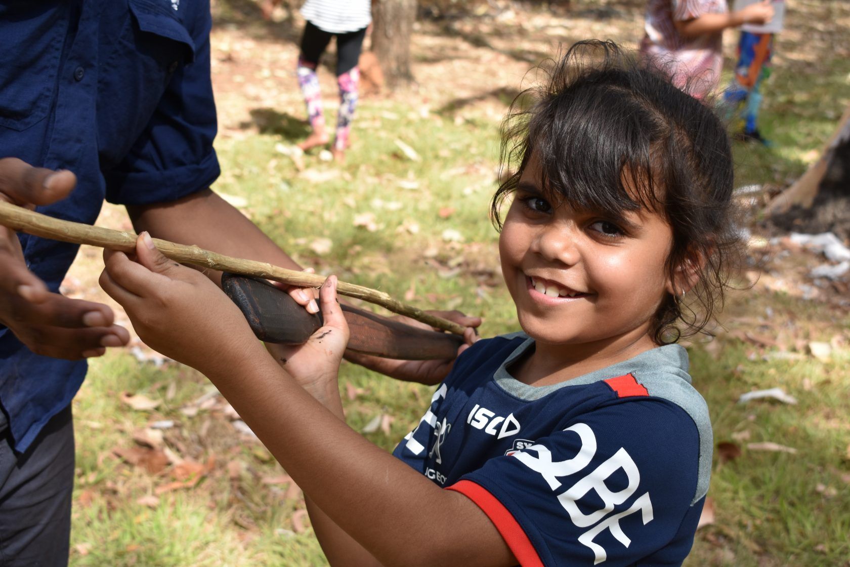 A student holding a stick outside