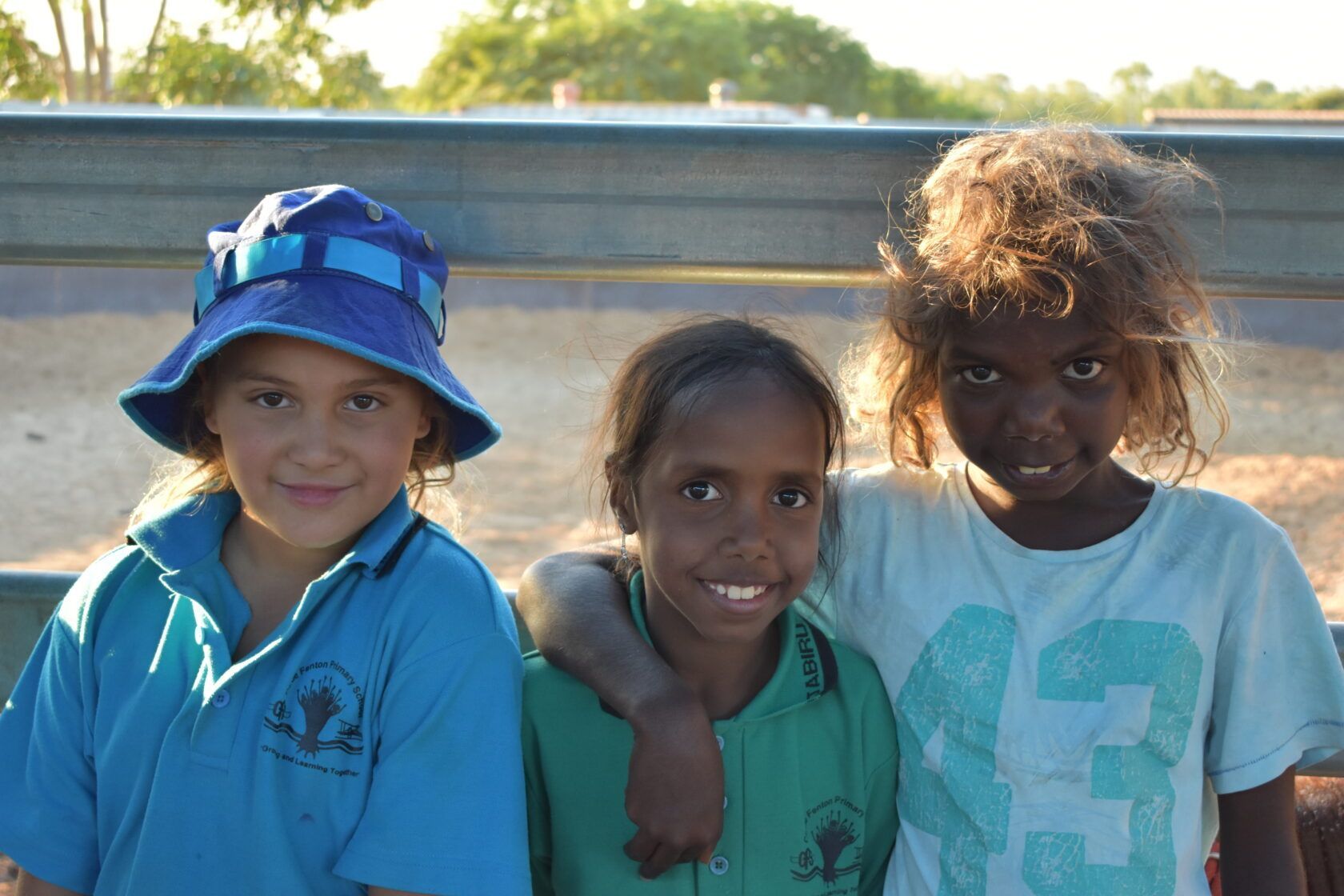 Three young girls are posing for a picture with one wearing a number 93 shirt