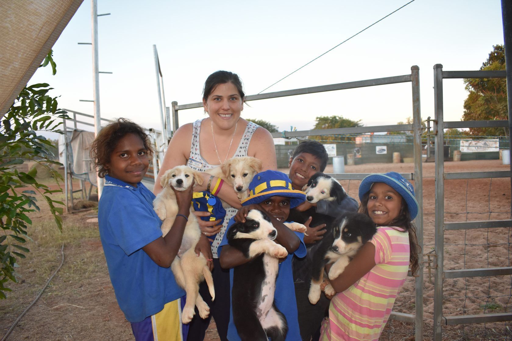 A group of people standing next to each other holding puppies.