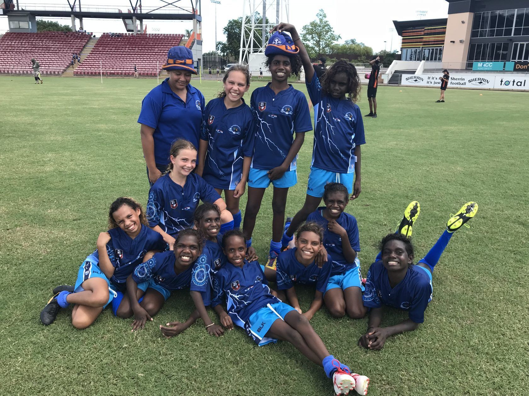 A group of children are posing for a picture on a field.