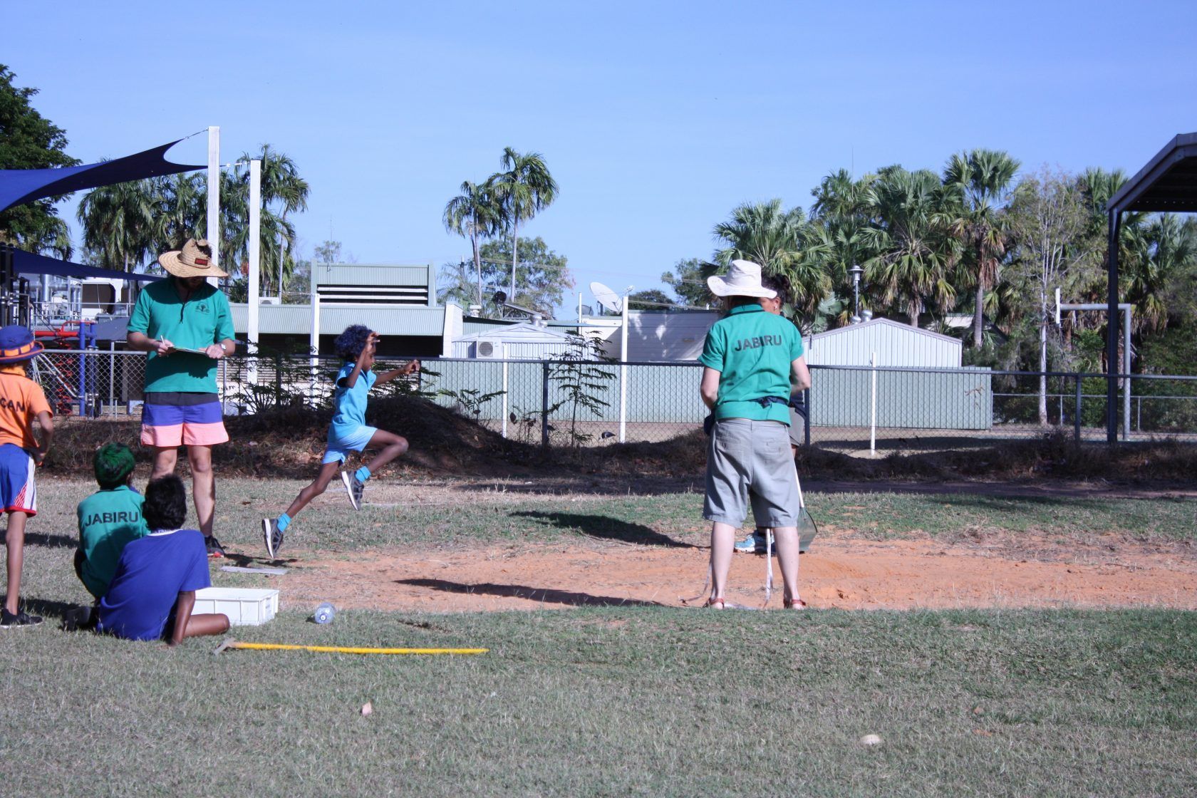 A group of people are watching a person run on a field