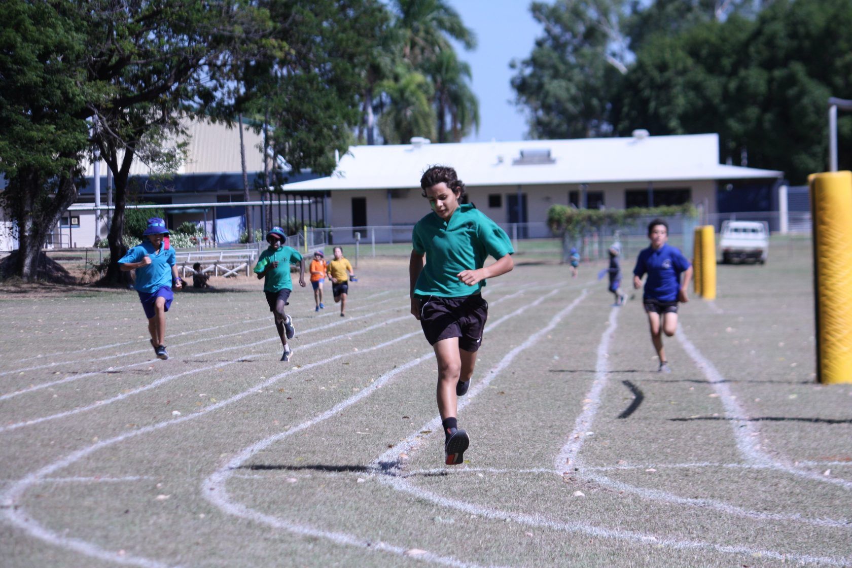A group of children are running on a track.