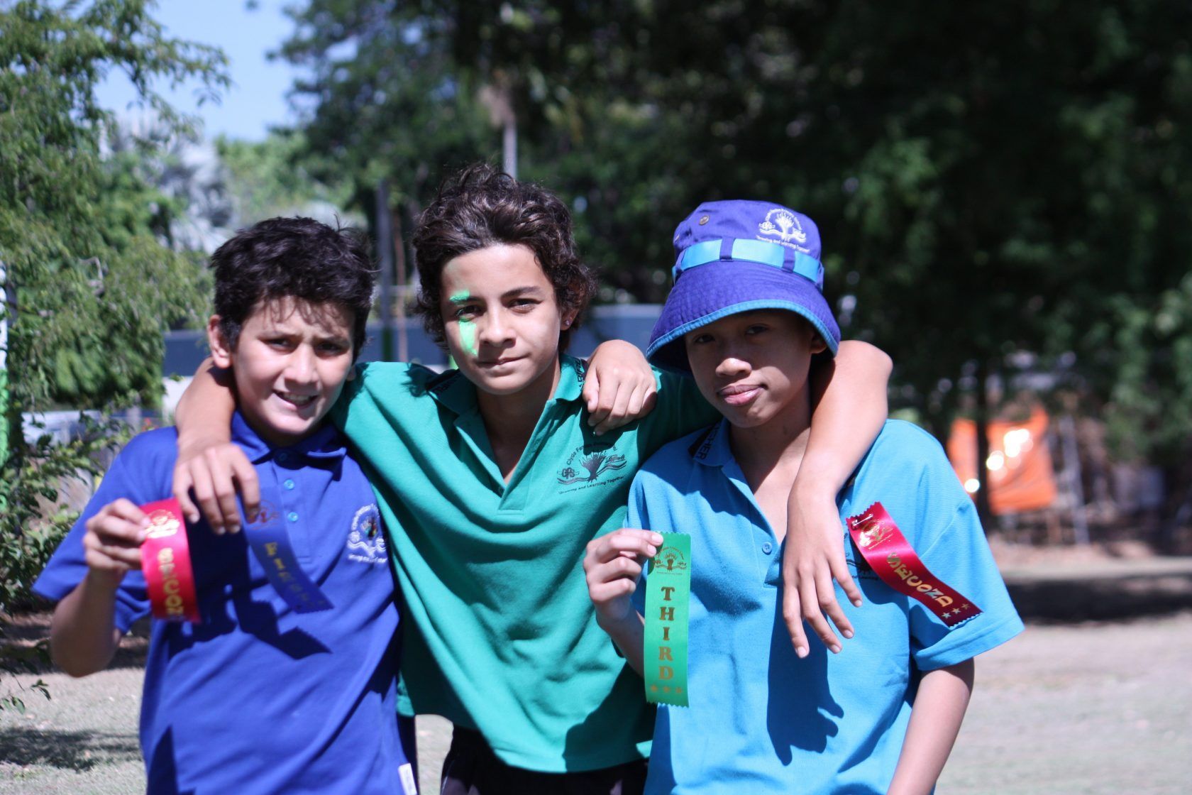 Three boys are posing for a picture and one has a green face painted