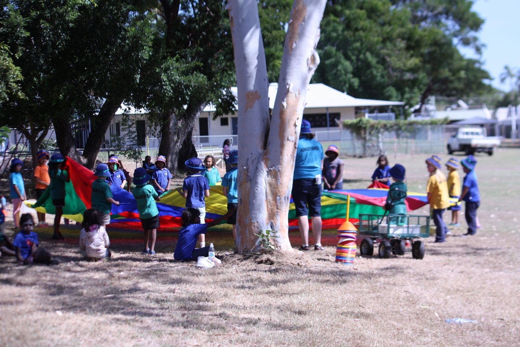 A group of children are playing with a parachute in a park