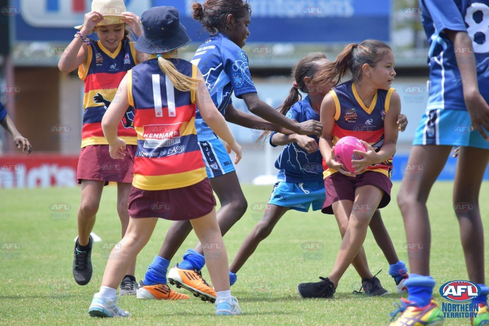 A group of young girls are playing soccer on a field.