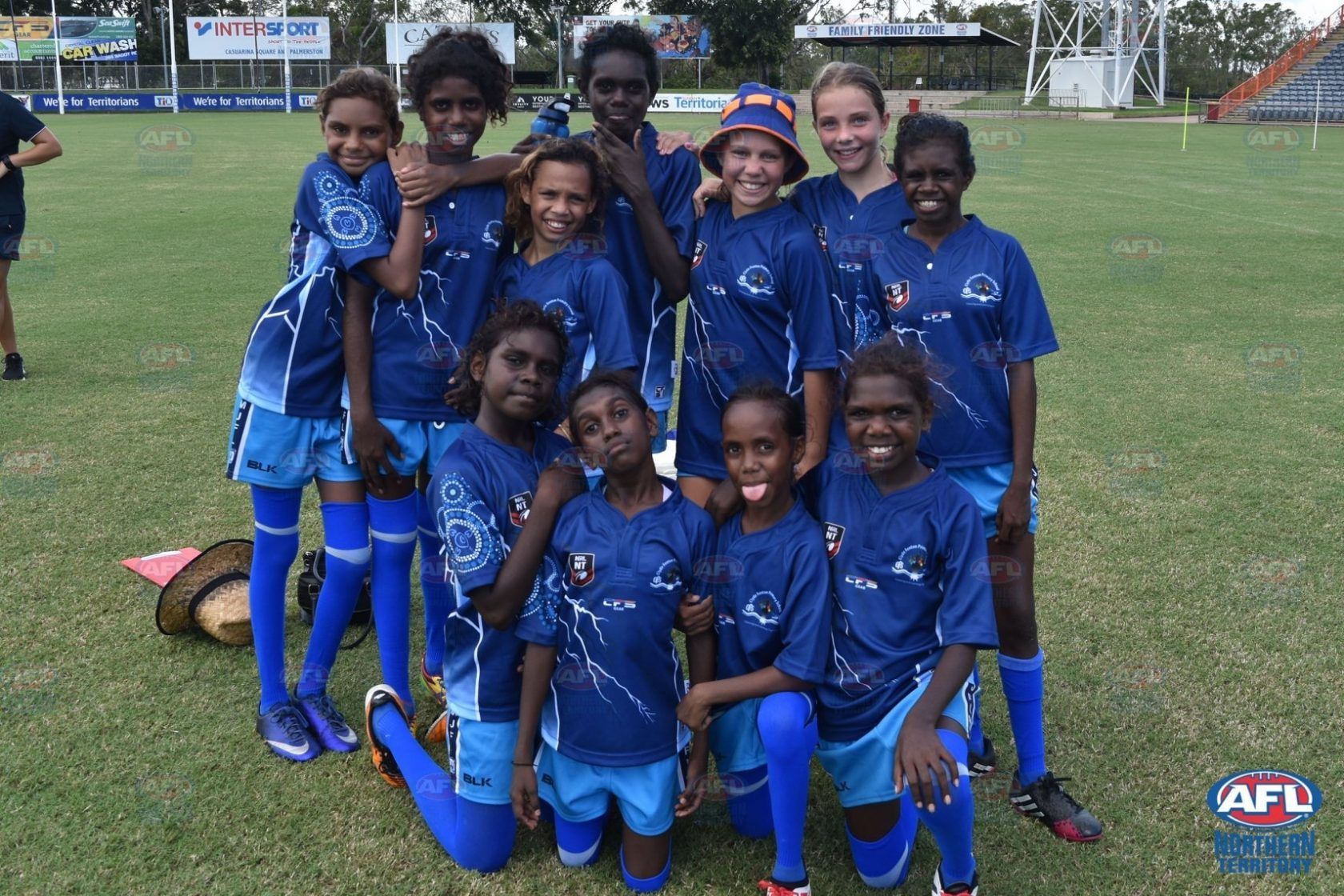 A group of children posing for a picture on a field with afl written on the bottom