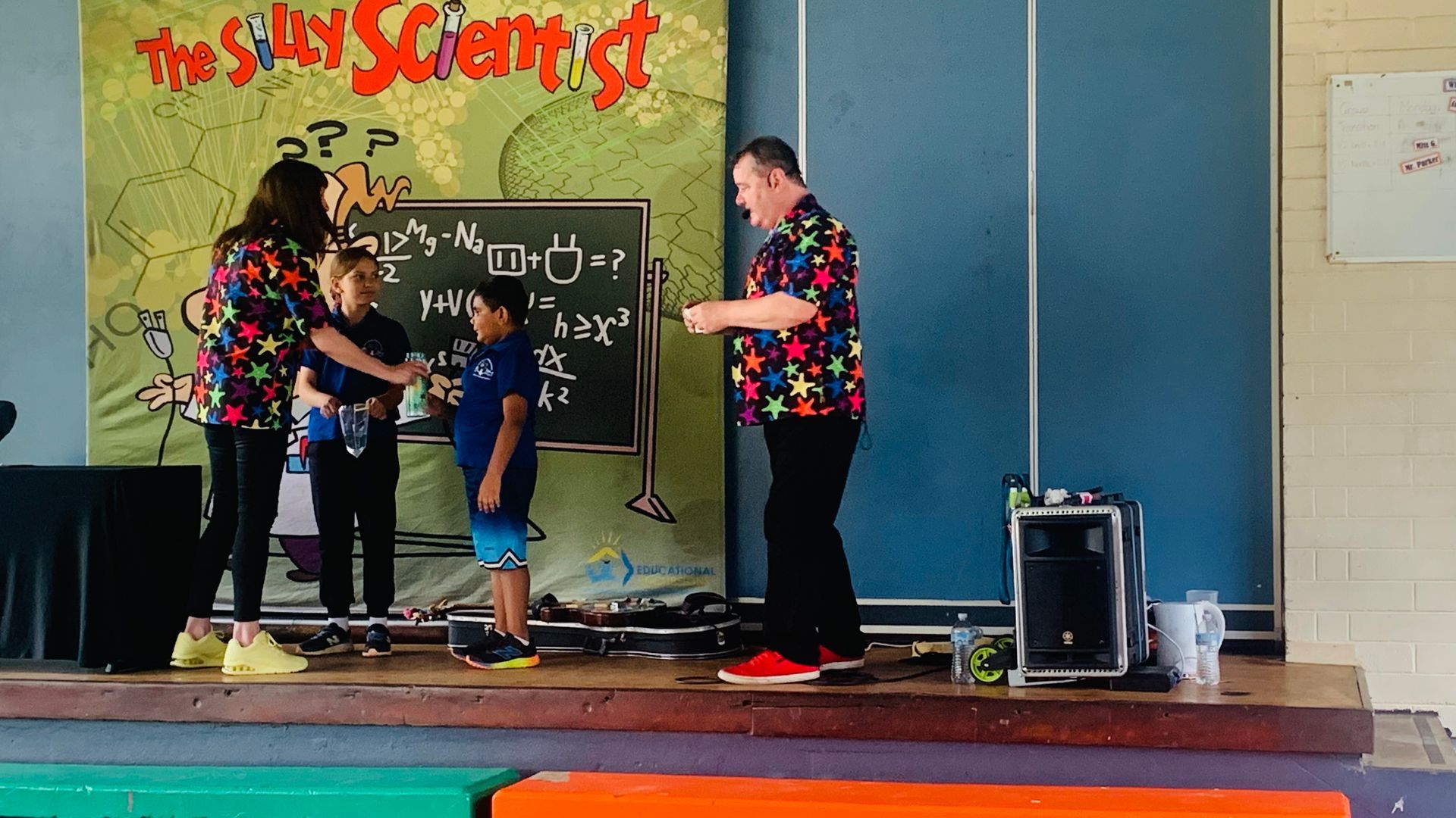 A group of people are standing on a stage in front of a sign that says the silver scientist
