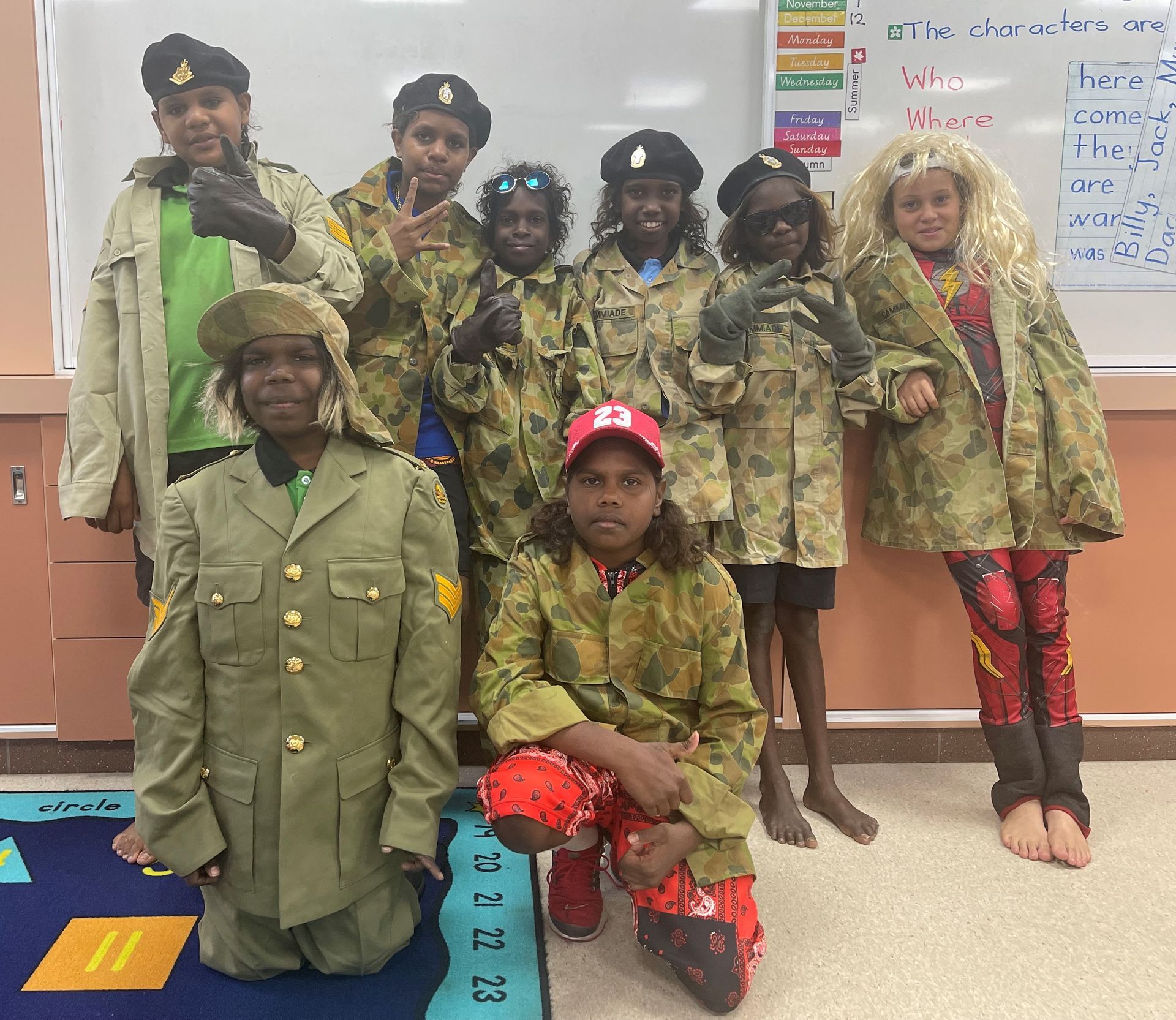 A group of children dressed in military uniforms pose for a picture