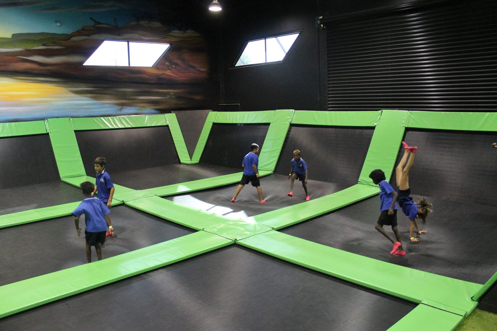 A group of children are playing on a trampoline.