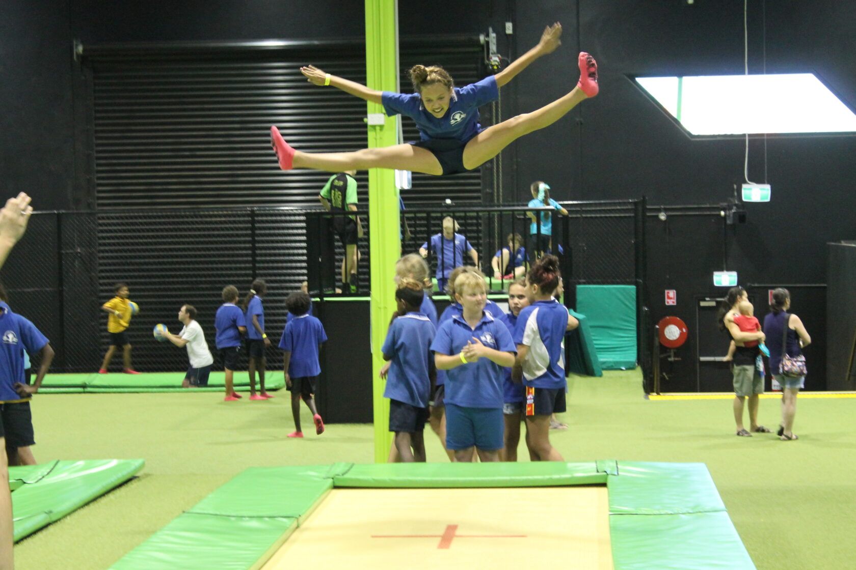 A girl is jumping in the air on a trampoline.