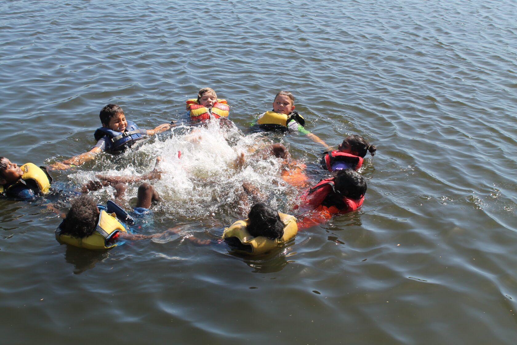 A group of children are playing in the water.