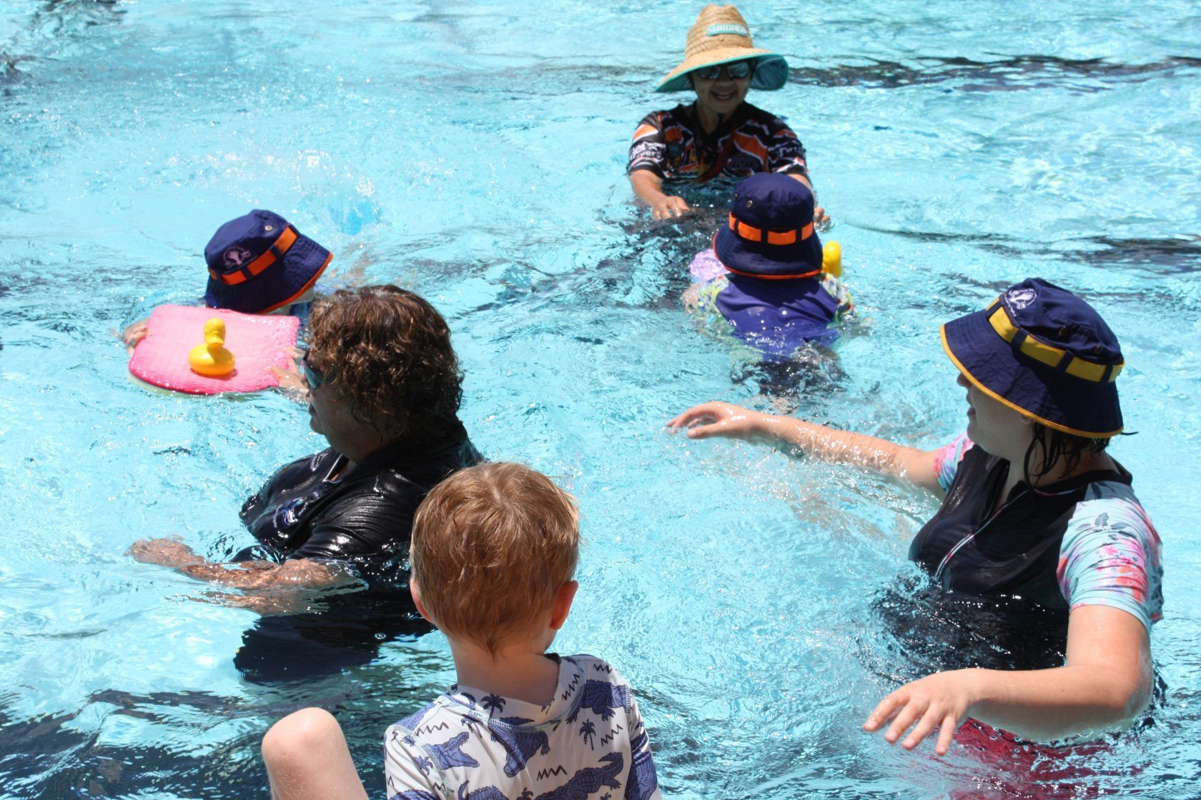 A group of people are swimming in a pool.