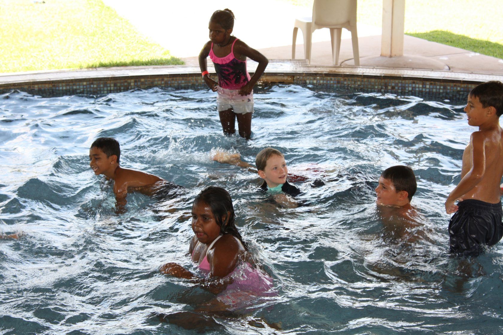 A group of children are playing in a swimming pool