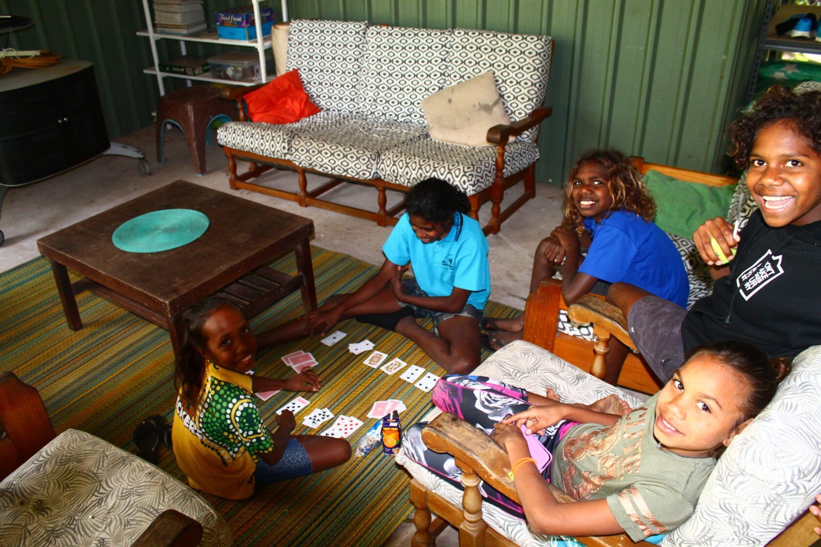 A group of children are playing cards in a living room