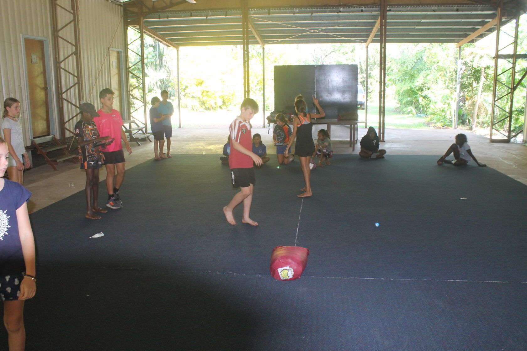 A group of children are playing a game in a large room.