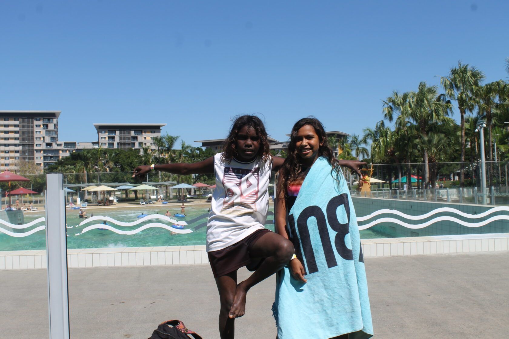 Two girls are standing next to each other with a towel that says ing on it.