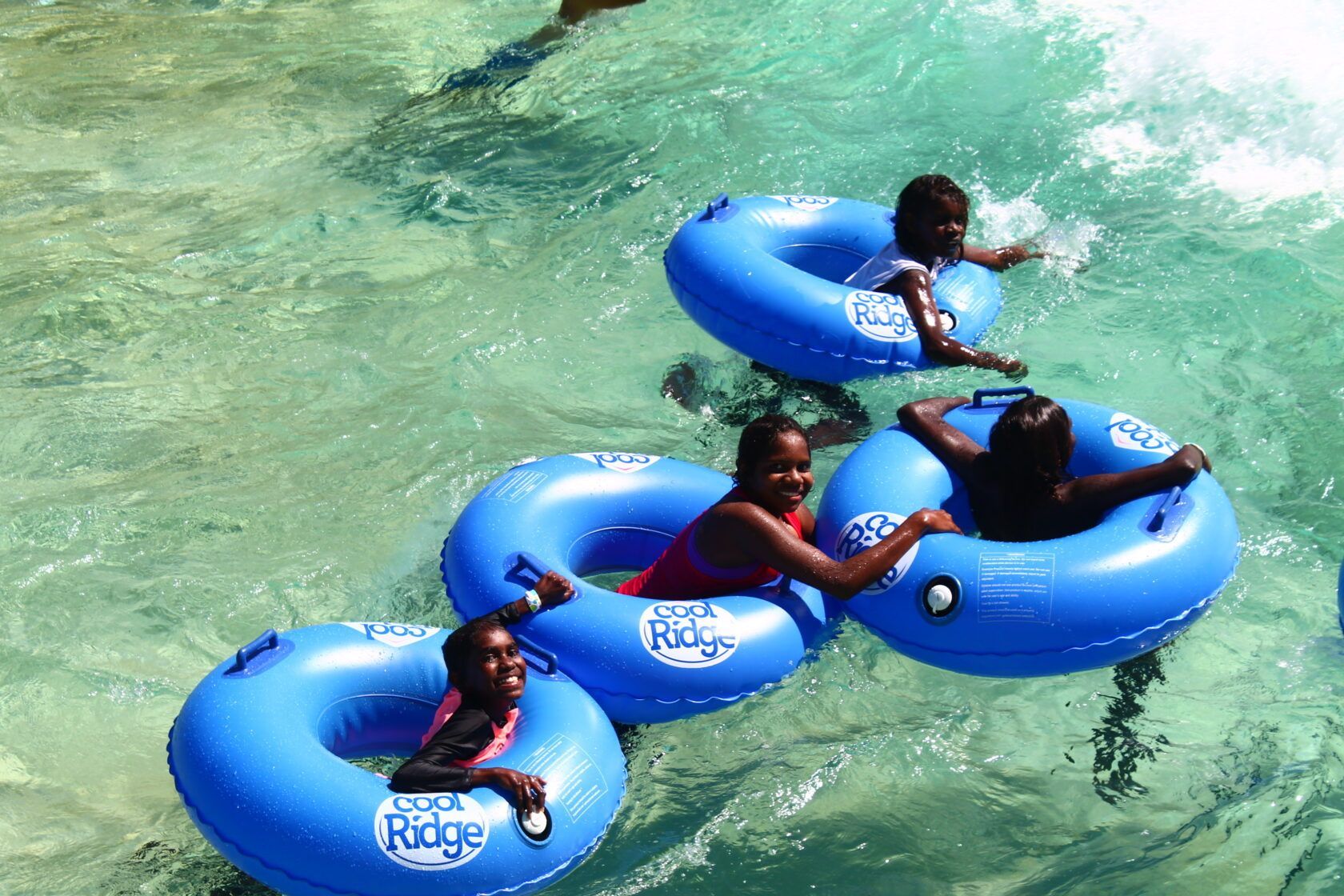 A group of people are floating on tubes that say ridge on them