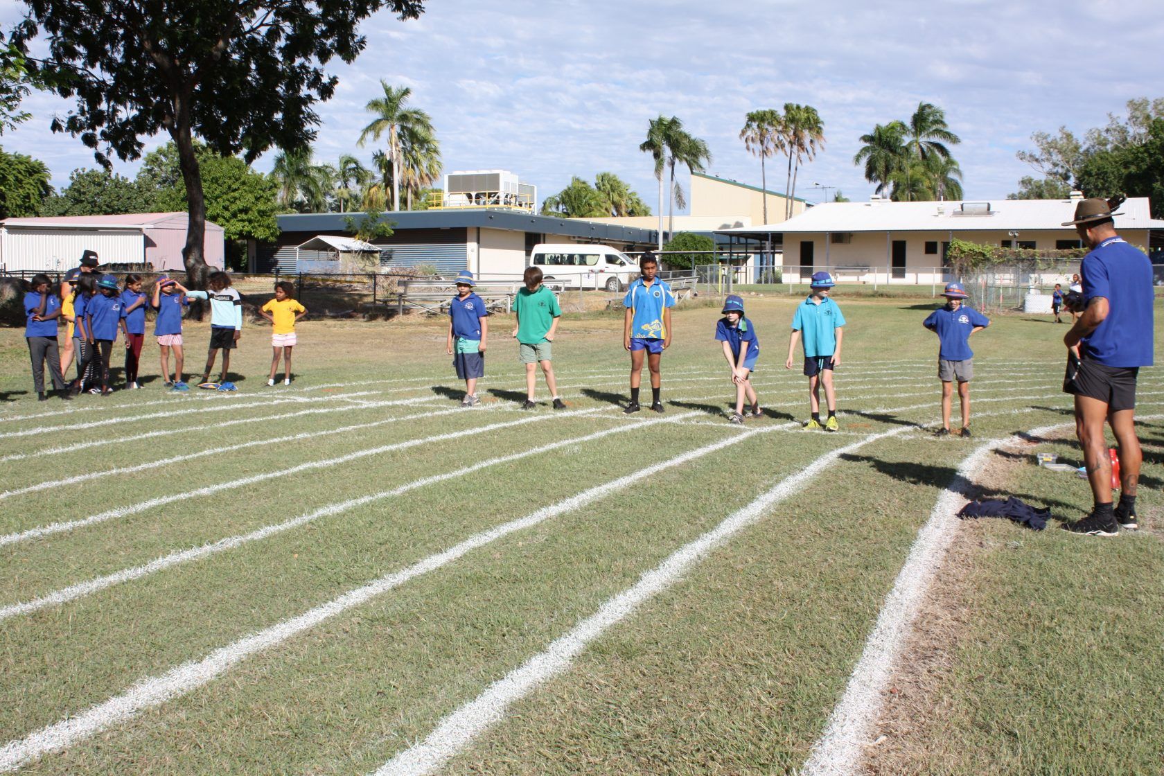 A group of children are standing on a track in a field