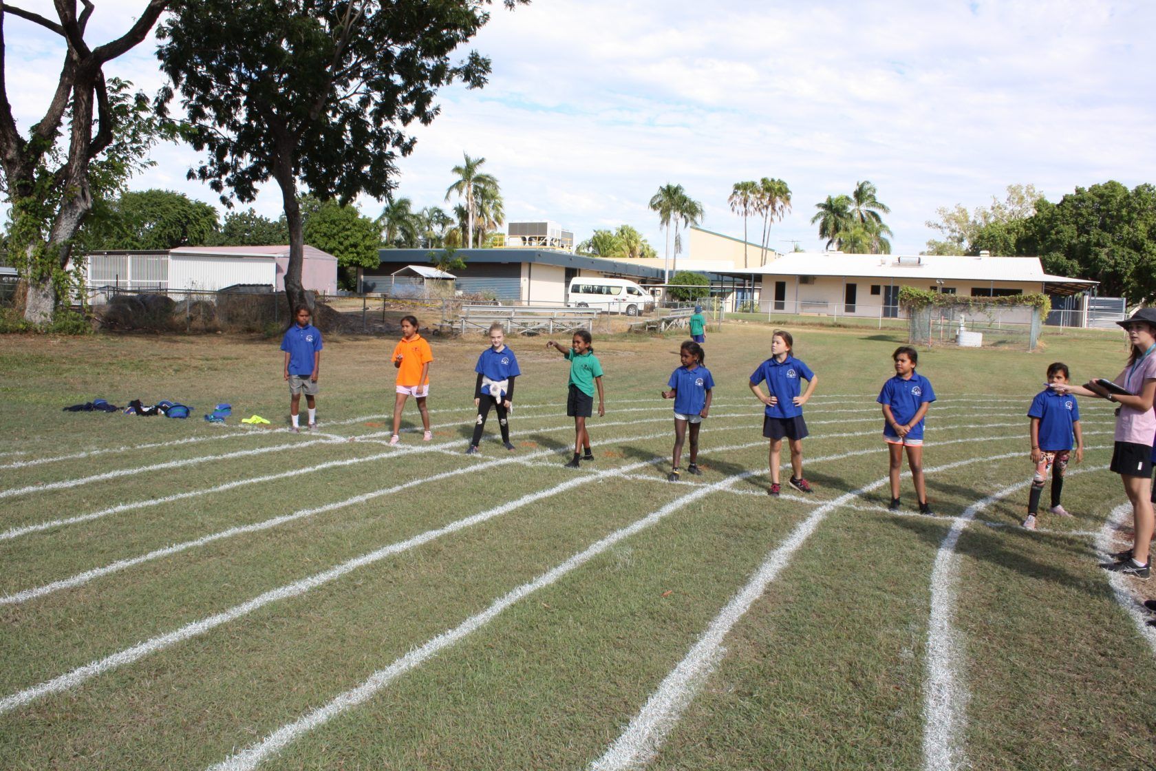 A group of children are standing on a track in a field