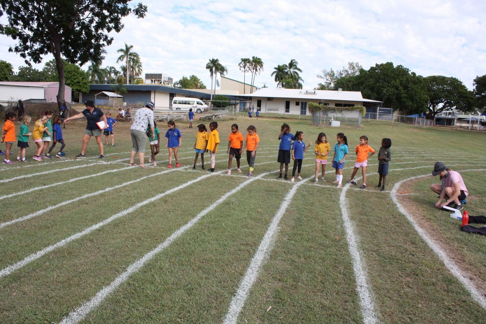 A group of children are standing on a track in a field