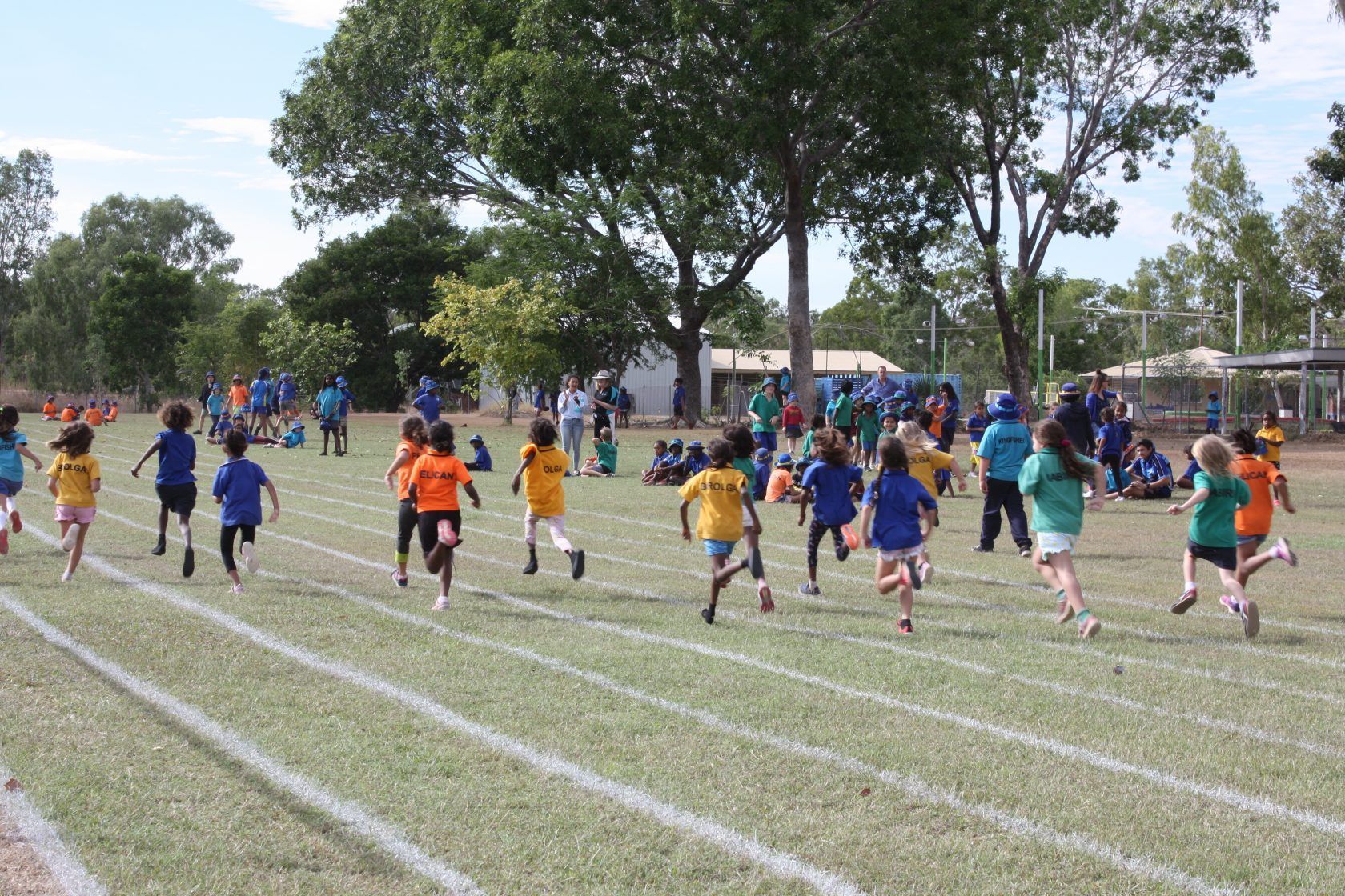 A group of children are running on a track.