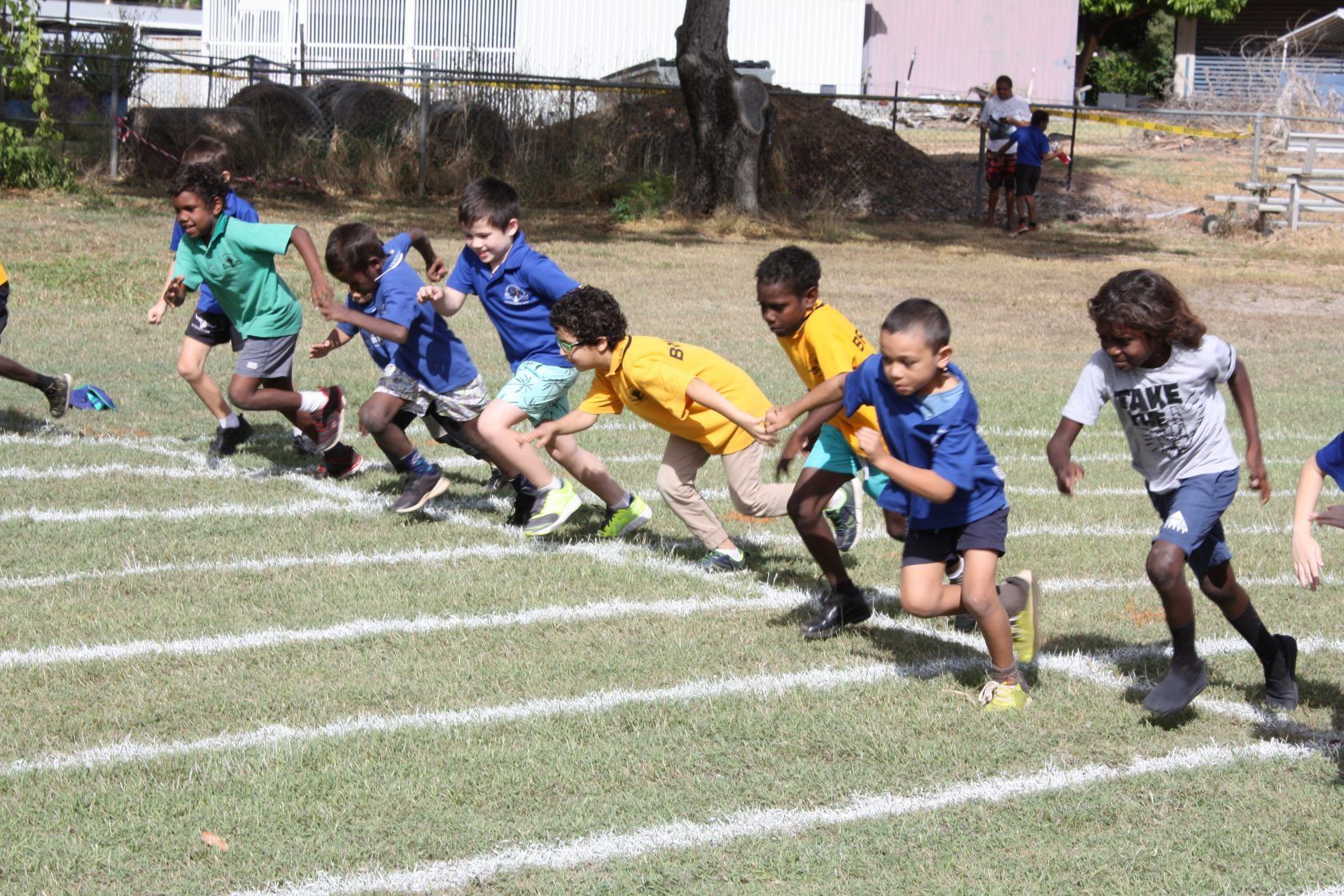 A group of children are running on a track.