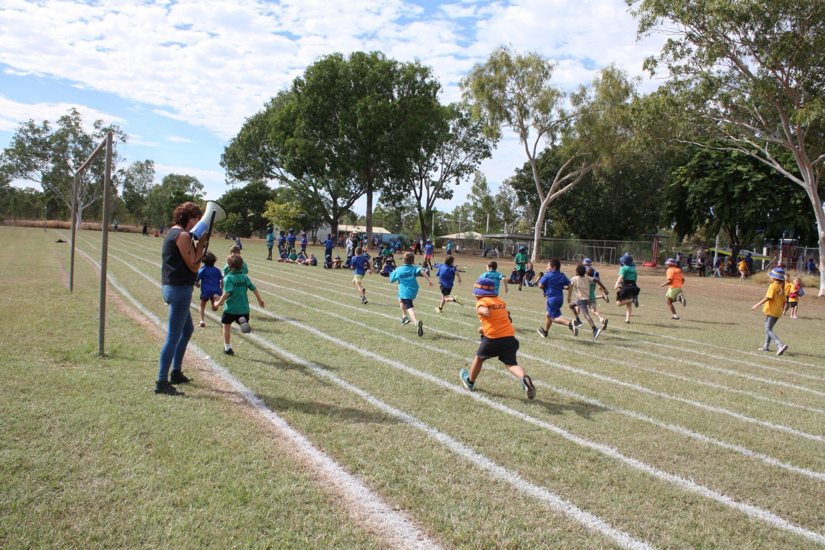 A group of children are running on a track.