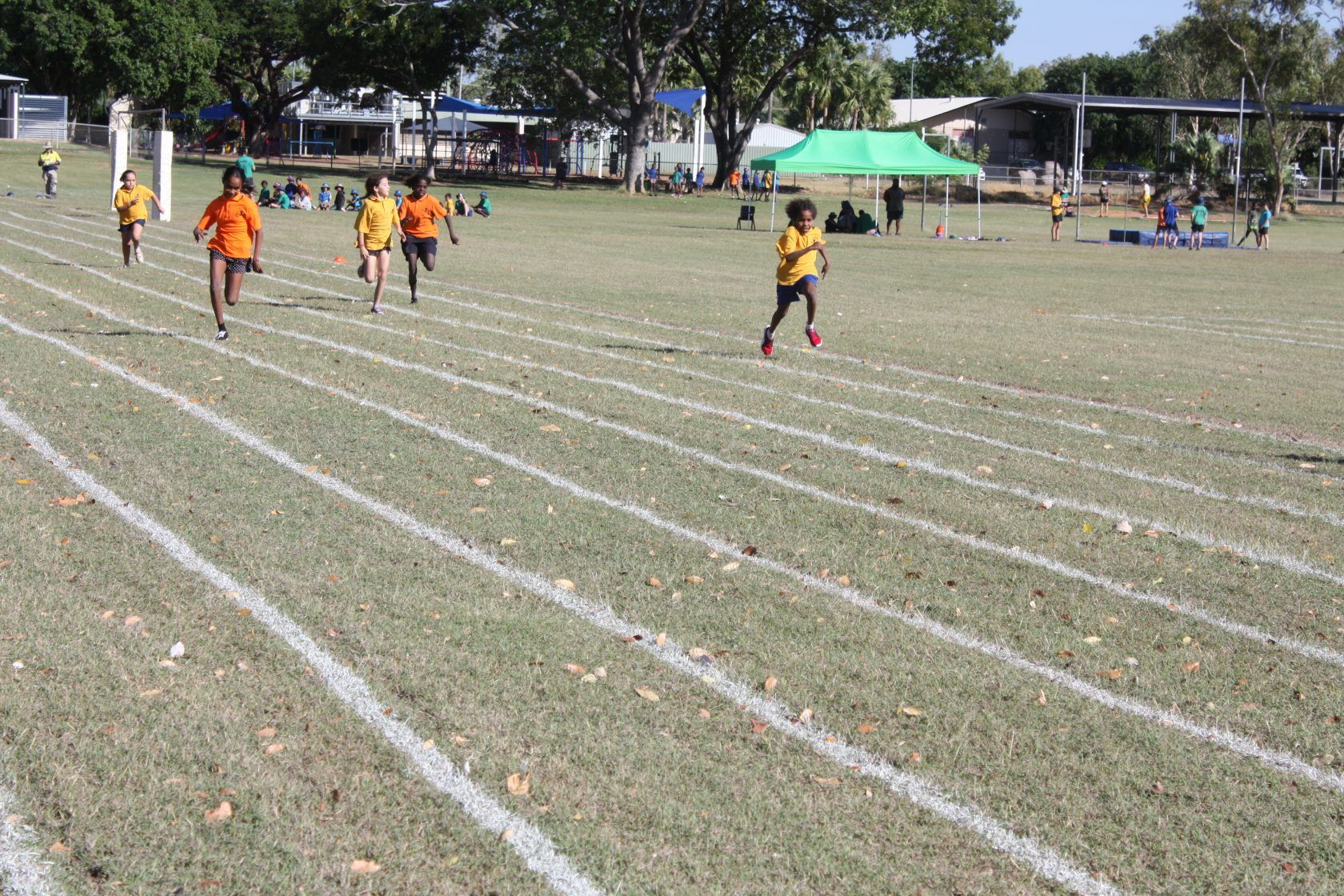 A group of children are running on a track.