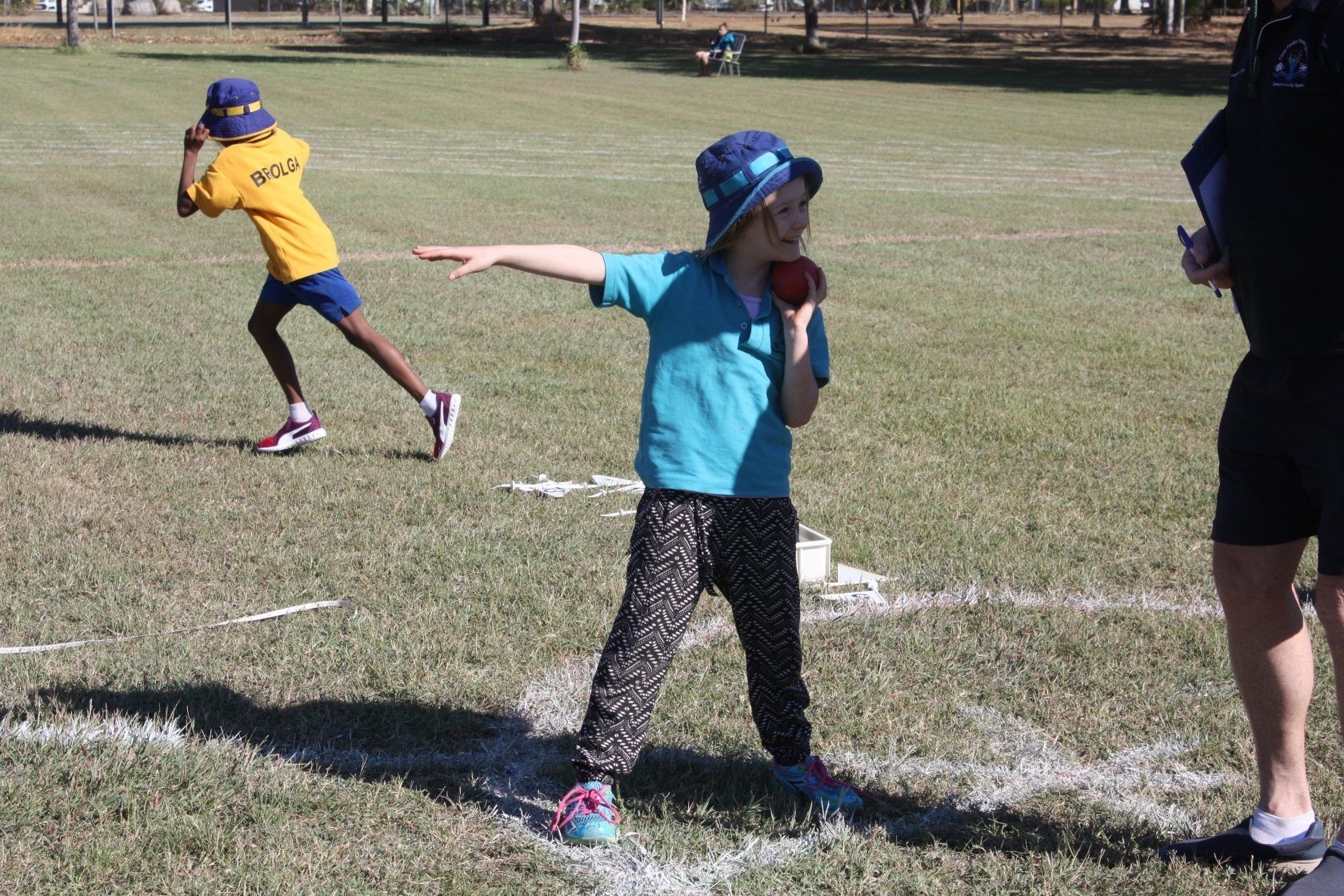 A young girl is throwing a frisbee on a field.