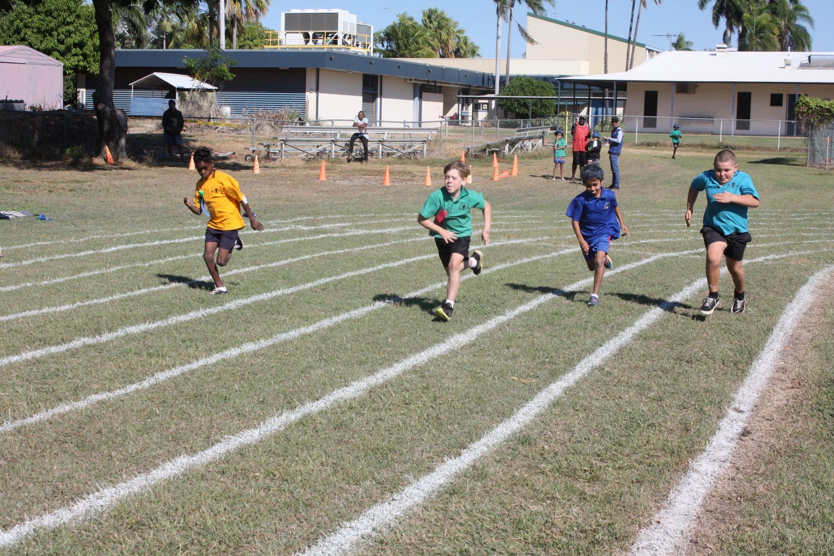 A group of children are running on a track.