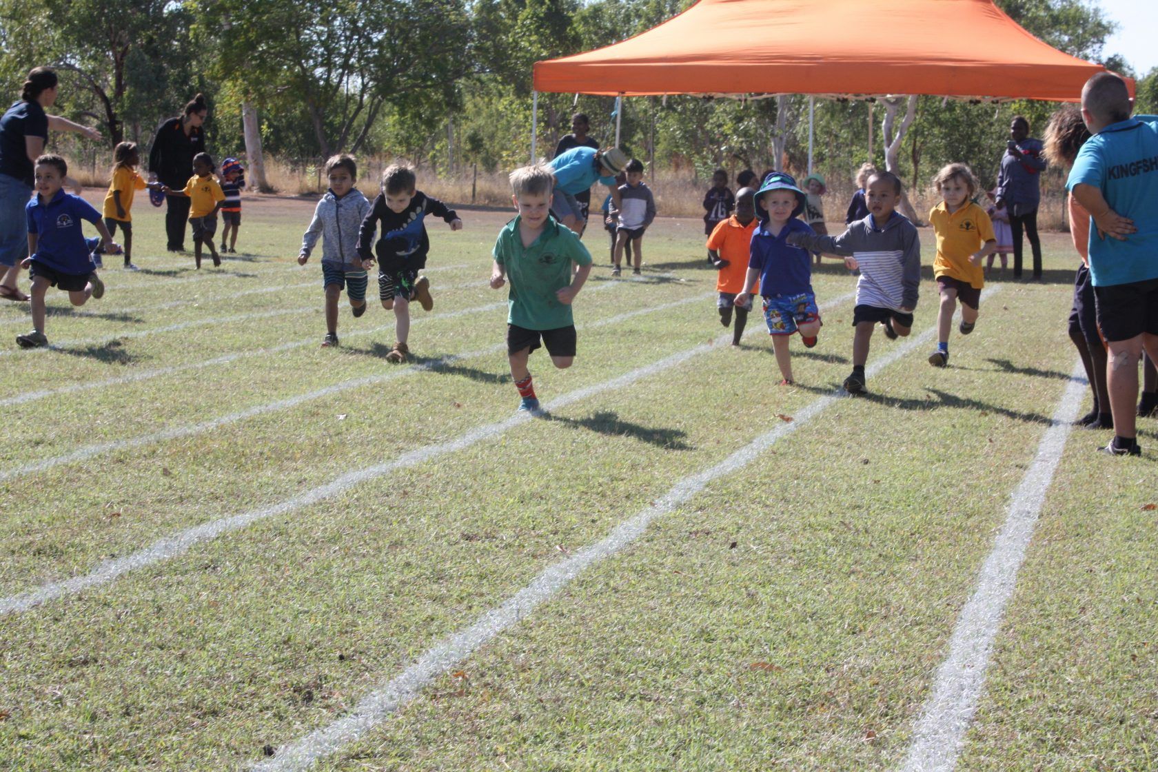 A group of children are running on a track.