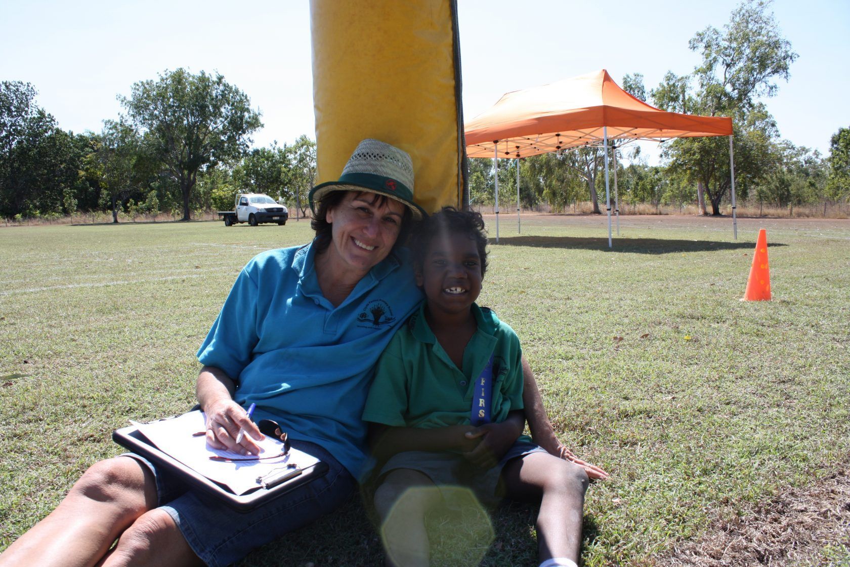 A woman sitting next to a child with a clipboard