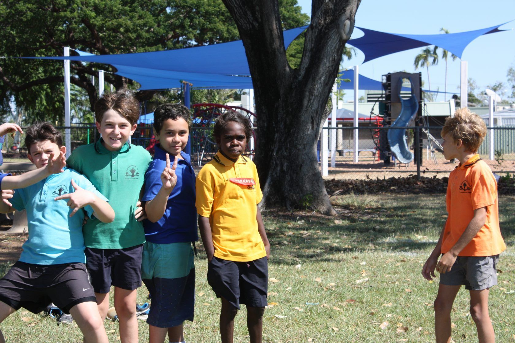 A group of young boys are posing for a picture in a park