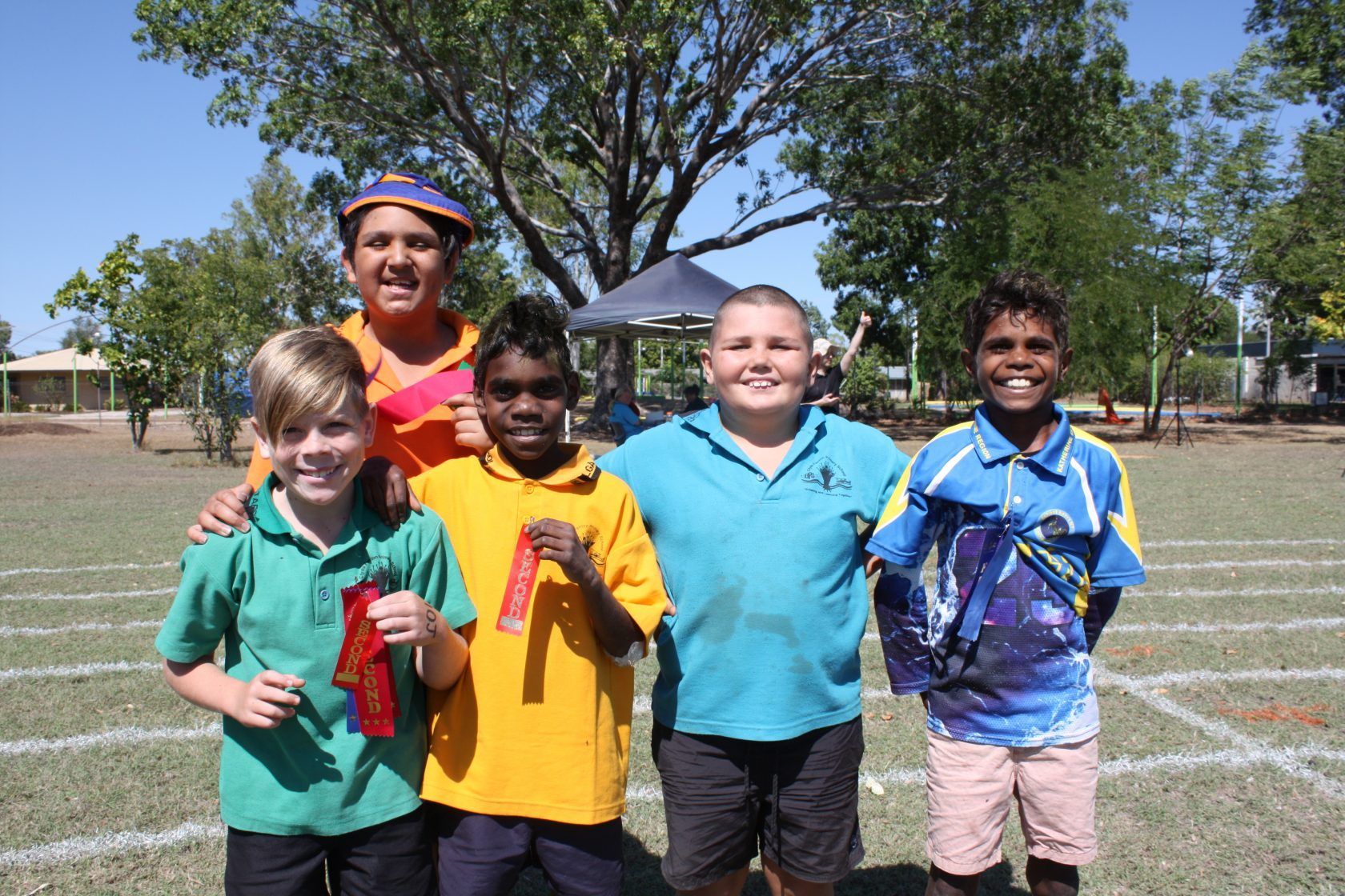 A group of young boys posing for a picture in a field