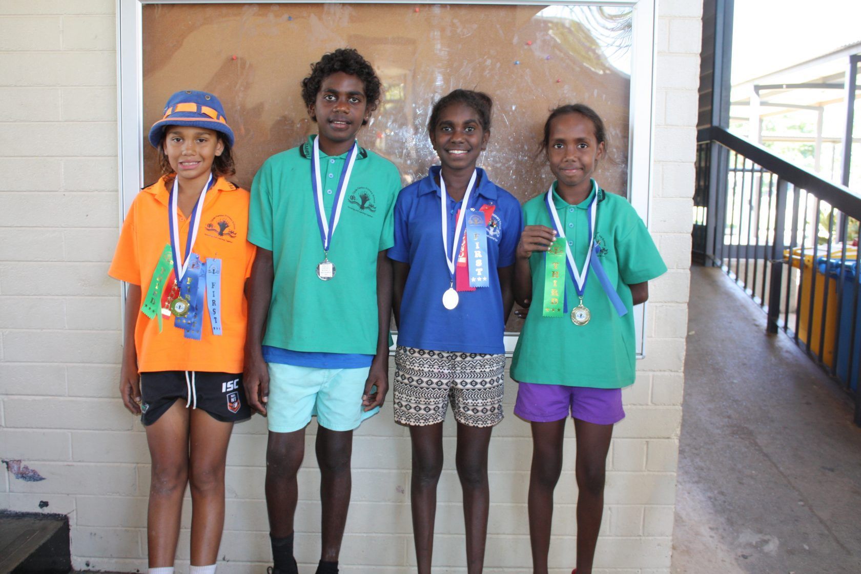 A group of young people standing next to each other with medals around their necks